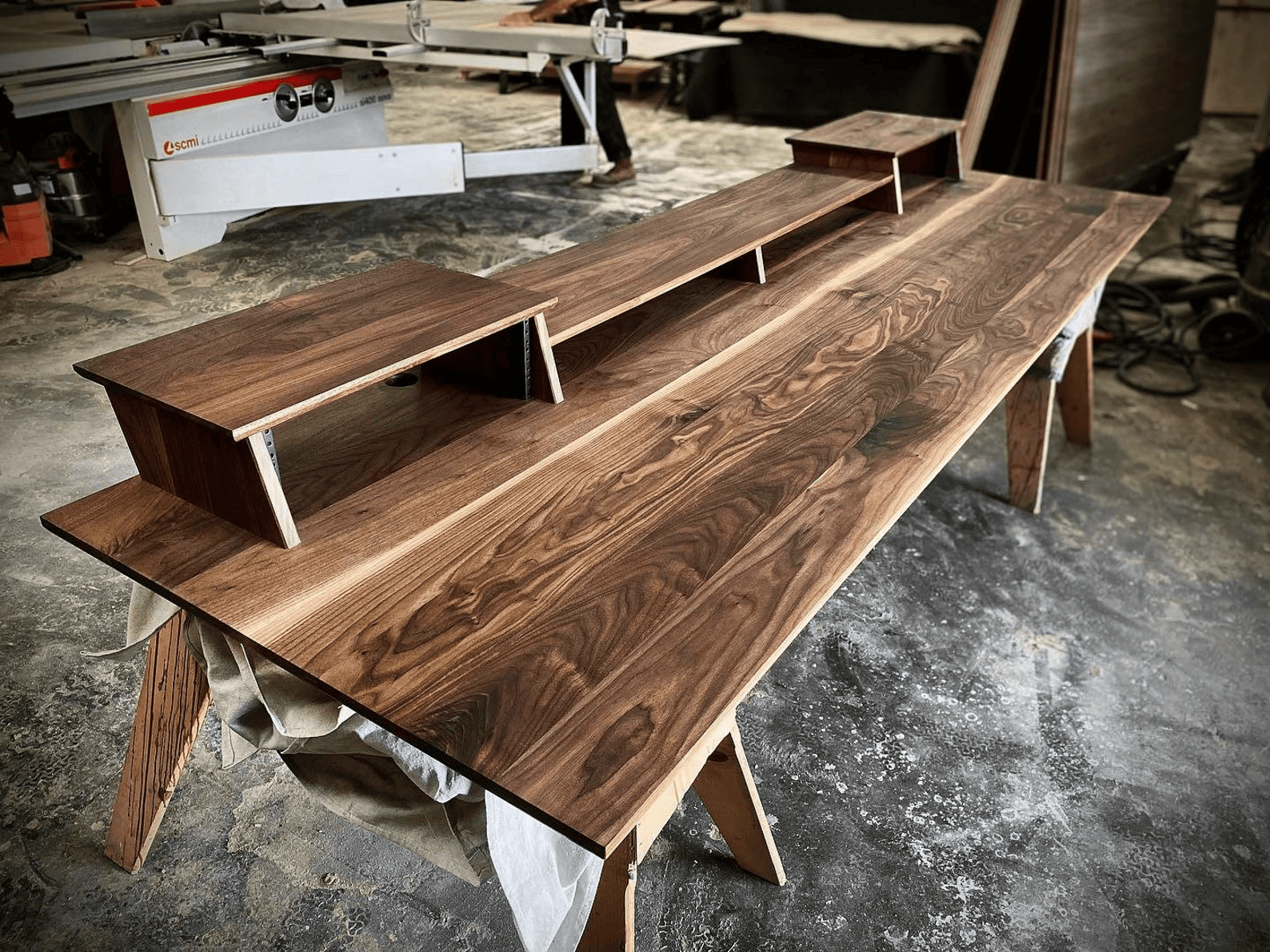 Walnut studio desk with tiered design in workshop